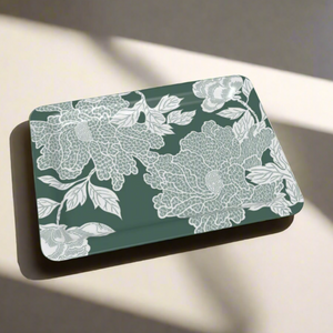 A stylish rectangular tray featuring intricate white floral linework on a muted green background.