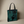 Tote bag featuring a dark teal peony and leaf katagami pattern on a black background, with black handles and a dark blue interior lining.
