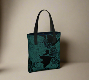 Tote bag featuring a dark teal peony and leaf katagami pattern on a black background, with black handles and a dark blue interior lining.