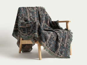 Patterned blanket draped over a wooden chair on a white background