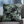 Gray armchair with a decorative pillow featuring green leaf patterns in a living room setting.