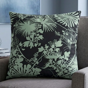 Gray armchair with a decorative pillow featuring green leaf patterns in a living room setting.