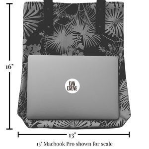 City Tote bag with a 13” MacBook Pro placed on top for size reference. The tote measures 16 inches in height and 13 inches in width, showing its spacious capacity.