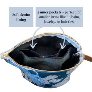 Open cosmetic bag with a soft denim lining and two inner pockets, highlighted by arrows and text. The bag features a gold metal zipper and a floral patterned exterior. The inner pockets are designed for small items like lip balm, jewelry, or hair ties.