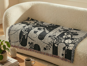 Dark blue and off-white woven blanket featuring a traditional Japanese katagami design of undulating vertical stripes interspersed with flowing floral motifs of leaves and clusters of small blossoms on vines.