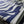 Microfiber and cotton terry towel hanging against a tiled wall, showcasing a dark blue and white ‘Trellis’ pattern. Hemmed edges add durability.