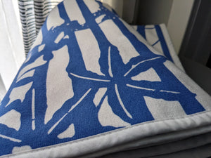 Close-up of a microfiber and cotton terry towel featuring a bold blue and white ‘Trellis’ floral pattern.