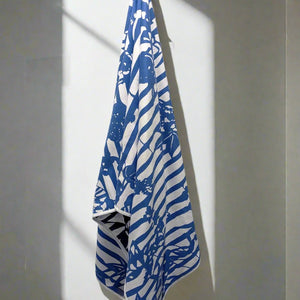 Microfiber and cotton terry towel featuring a bold blue and white ‘Trellis’ floral pattern.