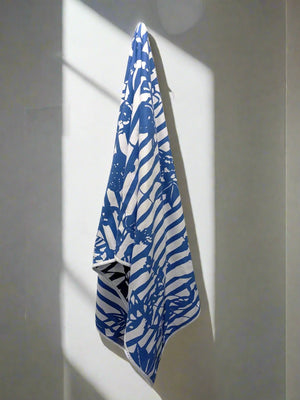 Microfiber and cotton terry towel featuring a bold blue and white ‘Trellis’ floral pattern.