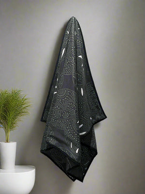 Microfiber and cotton terry towel with a black and green abstract circular ‘Fiesta’ pattern. Hemmed edges.