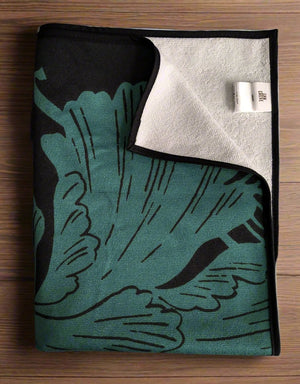 Microfiber and cotton terry towel in teal and black with a bold peony floral design. Soft, absorbent, and hemmed for durability.