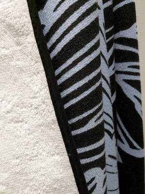 Microfiber and cotton terry towel with a black and light blue peony floral pattern.