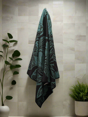 Microfiber and cotton terry towel in teal and black with a bold peony floral design. Soft, absorbent, and hemmed for durability.