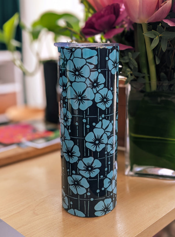 Stainless steel 20 oz tumbler showcasing a close-up of blue cherry blossoms on a dark navy background. Includes a clear lid and reusable straw, blending functionality with artistry.