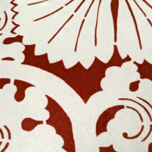 Luxurious velvet throw pillow with a deep red and white floral stencil design, influenced by Japanese artistry.