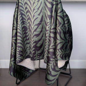 Patterned green and black blanket draped over a chair in a kitchen setting