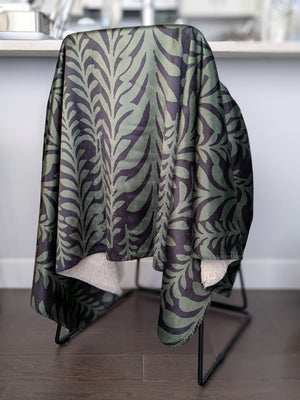 Patterned green and black blanket draped over a chair in a kitchen setting