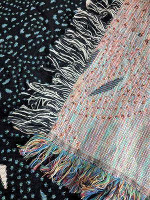 Woven blanket featuring two distinct patterns. The left side shows the rear side of the blanket, and the right side shows the front side.