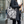 White and black tote bag with a pattern of large, swirling, stylized floral forms on the main body, complemented by a contrasting motif of fine, radiating lines resembling abstract leaves or starbursts.