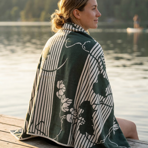 Dark green and off-white large towel featuring vertical stripes and a botanical pattern of stylized leaves and vines.