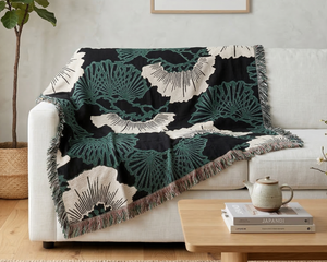Decorative blanket with geometric pattern draped over a sofa in a living room setting.