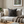 Cozy living room with a sofa, cushions, a teapot, and a book on a wooden table.