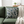 Throw pillow featuring stylized white and dark teal chrysanthemum blossoms on a muted green background with a fine geometric pattern (kanoko).