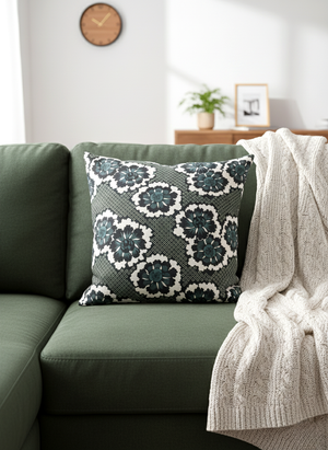Throw pillow featuring stylized white and dark teal chrysanthemum blossoms on a muted green background with a fine geometric pattern (kanoko).