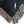 Corner edge of a woven blanket with a black background featuring a stylized pattern of scattered blue and green dots forming organic shapes.