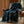 Patterned blanket draped over a brown leather chair in a cozy room with wooden walls and a small table.